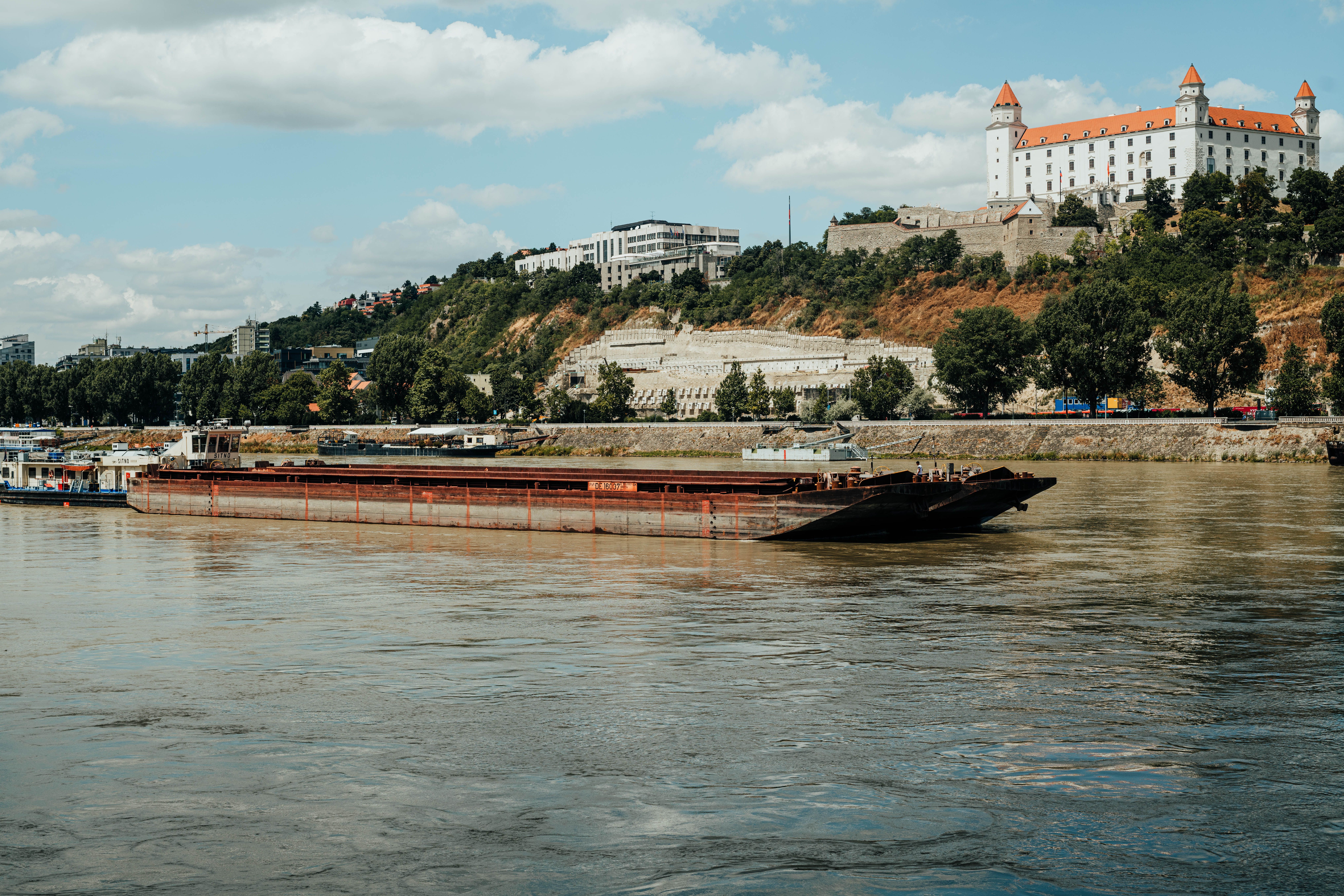River barge cruising the Danube with Bratislava Castle in the background, Slovakia